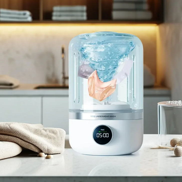 Smart laundry machine on a kitchen counter with clothes inside, displaying a digital timer.
